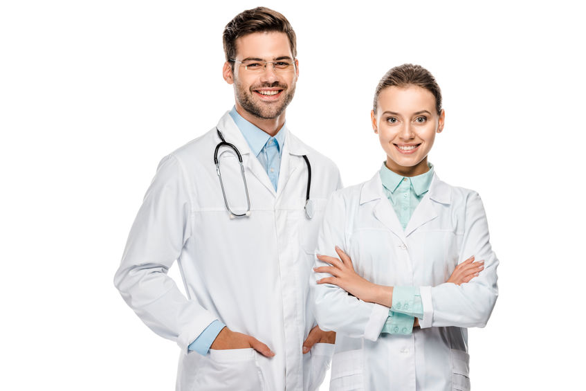 handsome happy male doctor standing near female colleague with crossed arms isolated on white